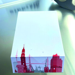 Notizblock weiß DinA6 unten schräg abgeschnitten und in rot Hamburg's Skyline uraufgedruckt